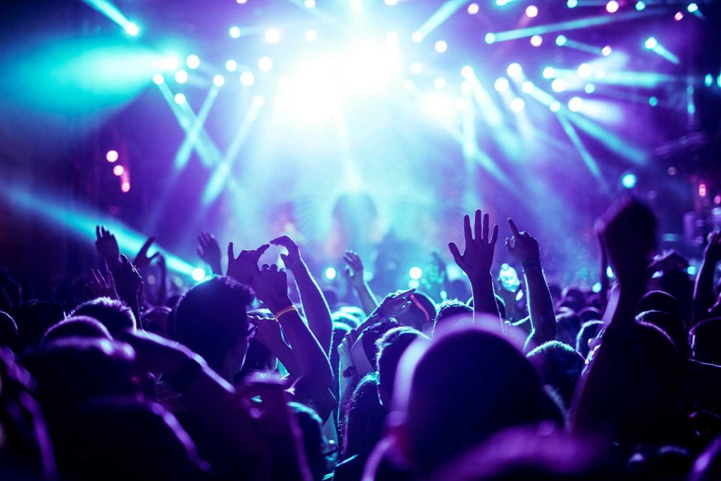 Eine überfüllte Konzerthalle mit Szene Bühne Lichter in Blautönen, Rock-Show Leistung, mit Menschen Silhouette, auf der Tanzfläche Luft während eines Konzertes Festival Von tsuguliev