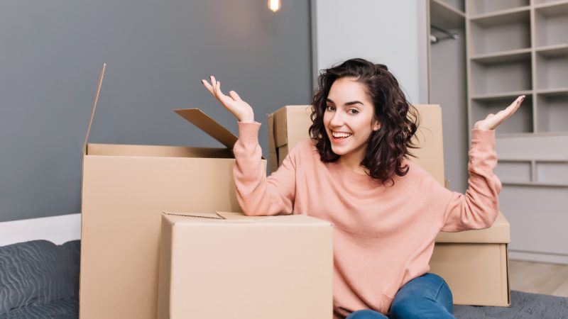 excited-young-woman-on-bed-surround-boxes-carton-smiling-in-modern-apartment-moving-to-new-flat-expressing-true-positive-emotions-at-new-home-with-modern-interior.jpg